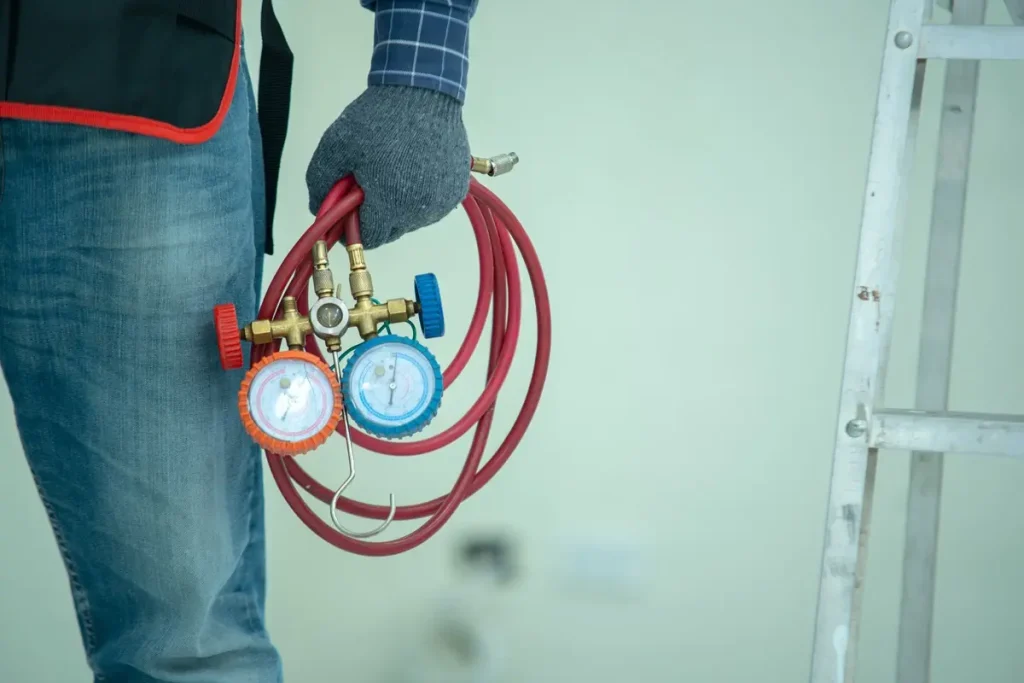 Close-up of the technician wearing a glove in their hand and holding an air pressure gauge.